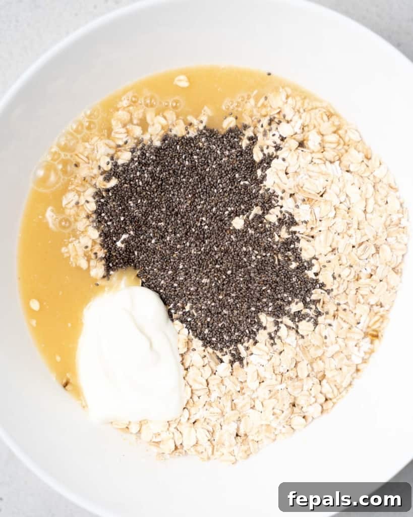 Velvet Peach Dream Oats 8 Adding milk, yogurt, oats and chia seeds to a bowl.