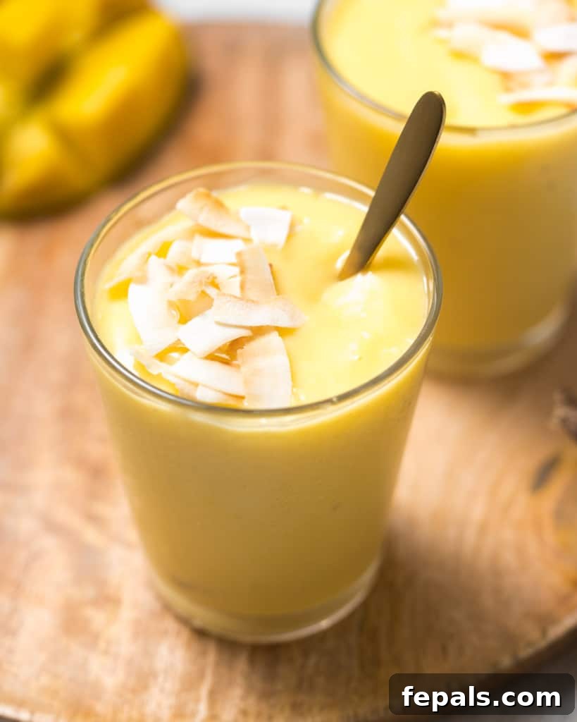 Tropical Mango Delight 12 Mango smoothies in glasses with a spoon.