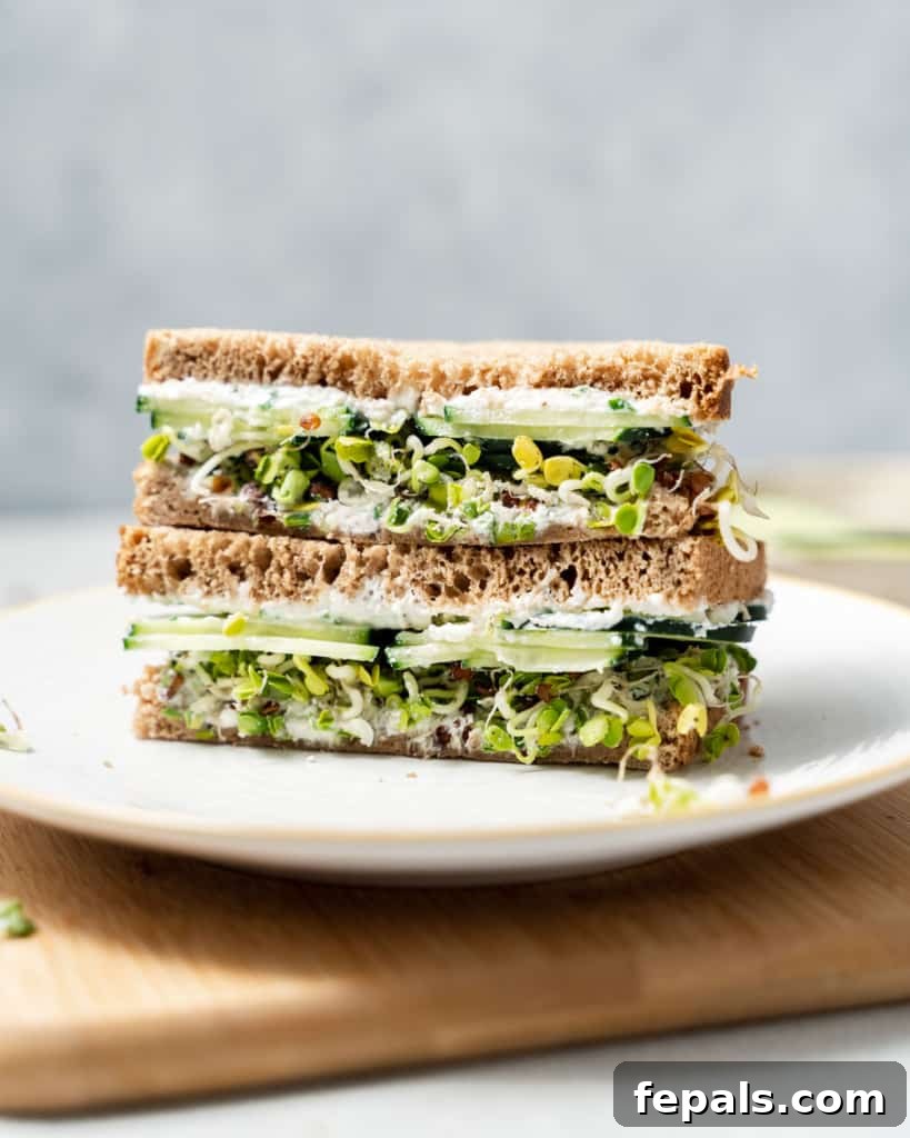 Elegant Cucumber Delights 2 Side shot of a cucumber sandwich sliced in half on a plate.