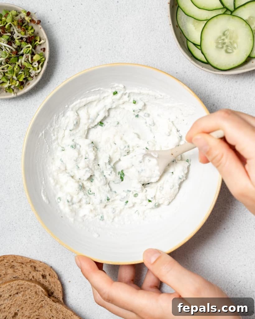 Elegant Cucumber Delights 6 Mixing together a cream cheese spread in a bowl.