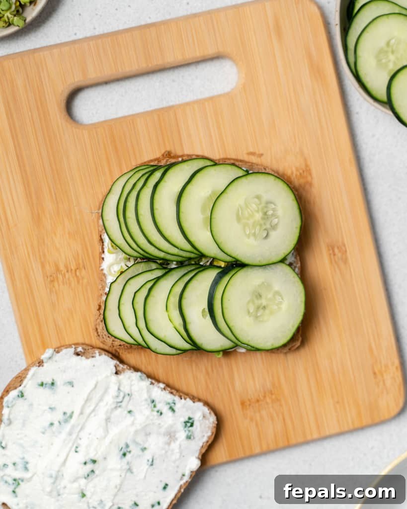 Elegant Cucumber Delights 9 Adding cucumber slices to a sandwich.