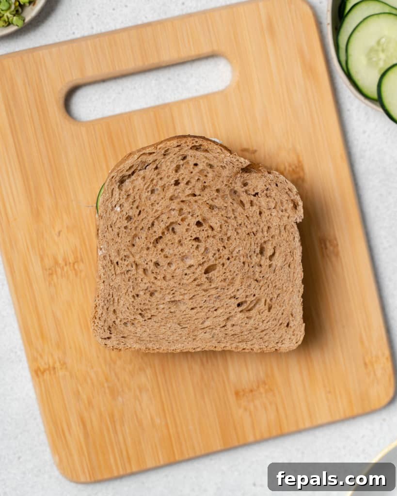 Elegant Cucumber Delights 10 Topping sandwich with a slice of bread.