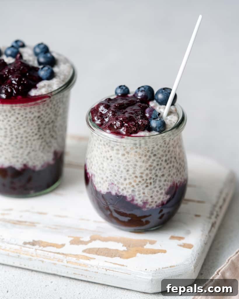 Chia seed pudding layered with blueberry sauce in small glass jars, ready to be served for a healthy breakfast.