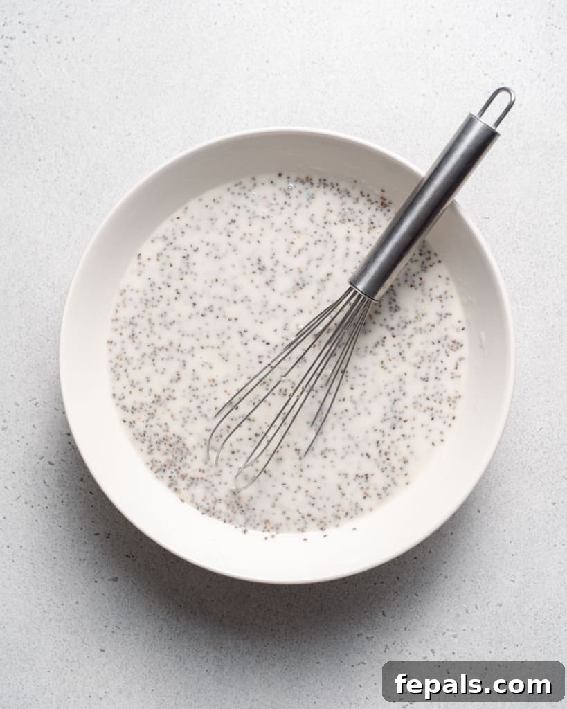 Chia seed pudding mixture setting in a white bowl, illustrating the pre-chilling stage.