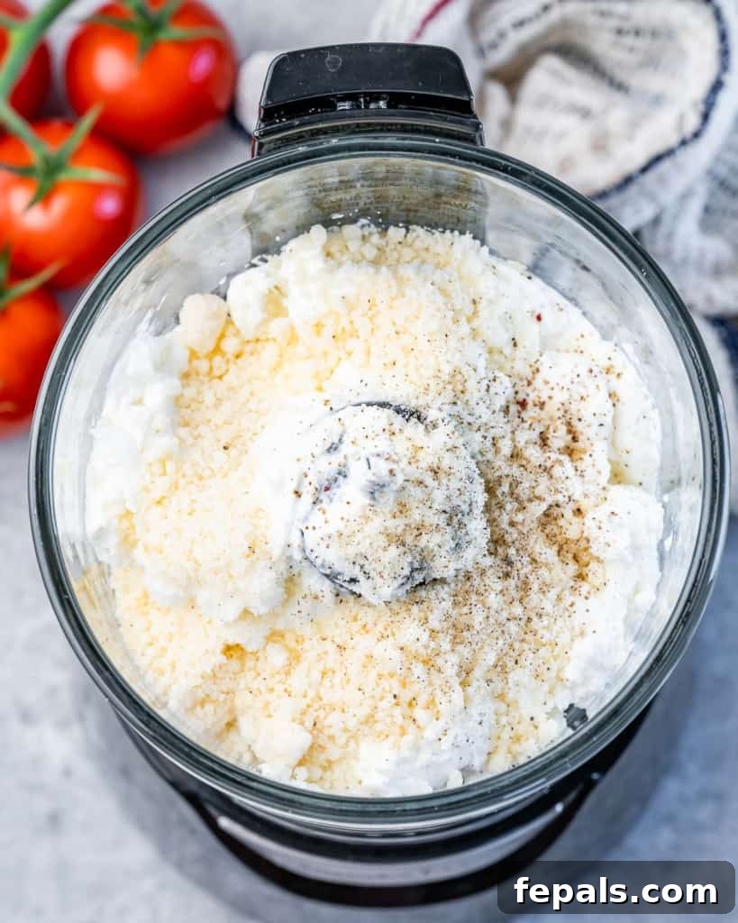 Fluffy Ricotta Dip 5 ricotta cheese and parmesan cheese added in a food processor, ready to be whipped.