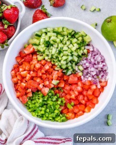 Adding diced veggies to a white bowl.