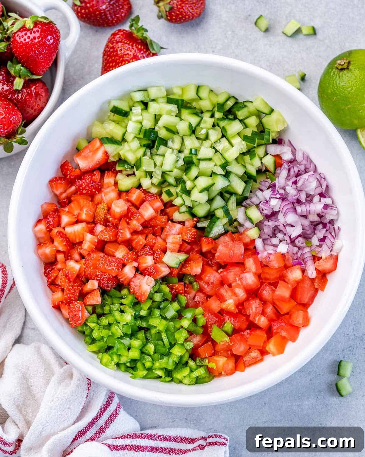 Adding diced veggies to a white bowl.