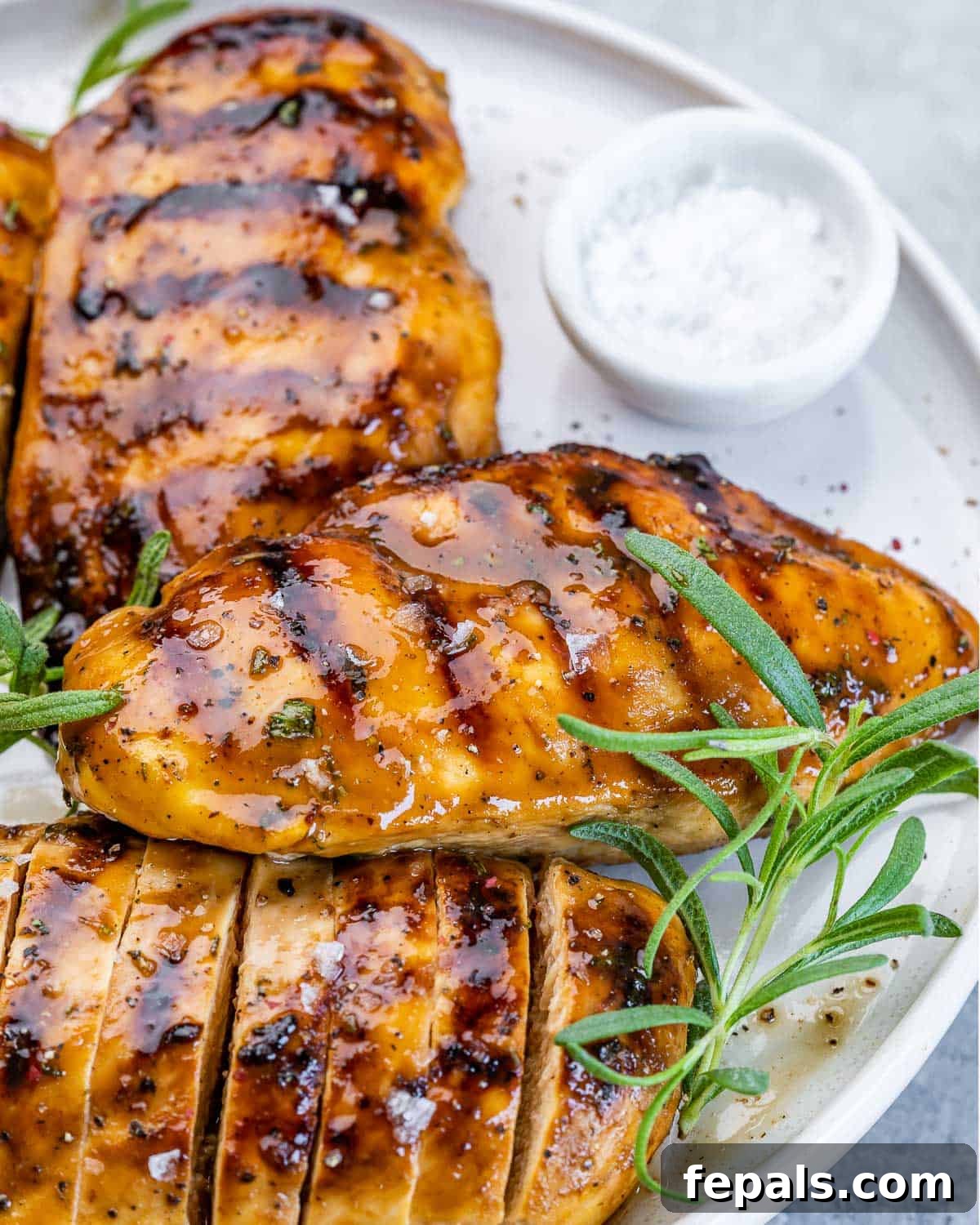Sweet and Savory Maple Rosemary Chicken 3 Maple glazed chicken garnished with fresh rosemary sprigs and a drizzle of glaze.