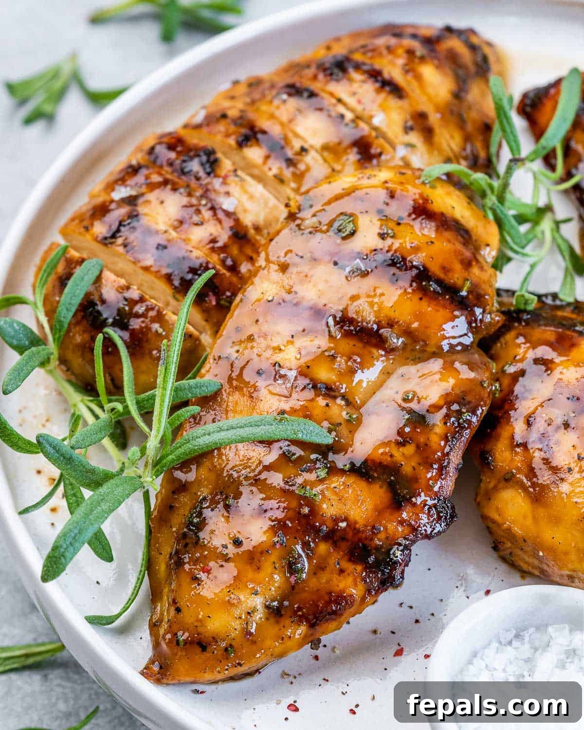 Sweet and Savory Maple Rosemary Chicken 10 Grilled chicken breast covered in a sticky marinade, served with a side of white sauce and fresh rosemary.
