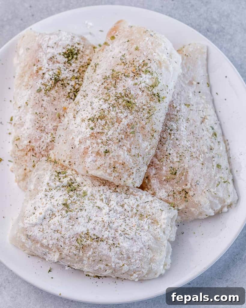 Bright Lemon Garlic Cod Bake 5 seasoned fresh uncooked cod on a plate