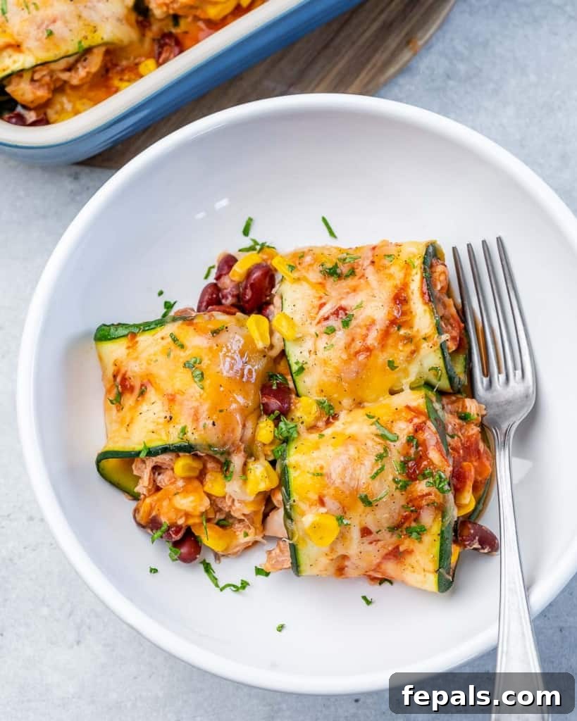 3 enchilada roll-ups plated on a white plate with a fork on the right side if it 