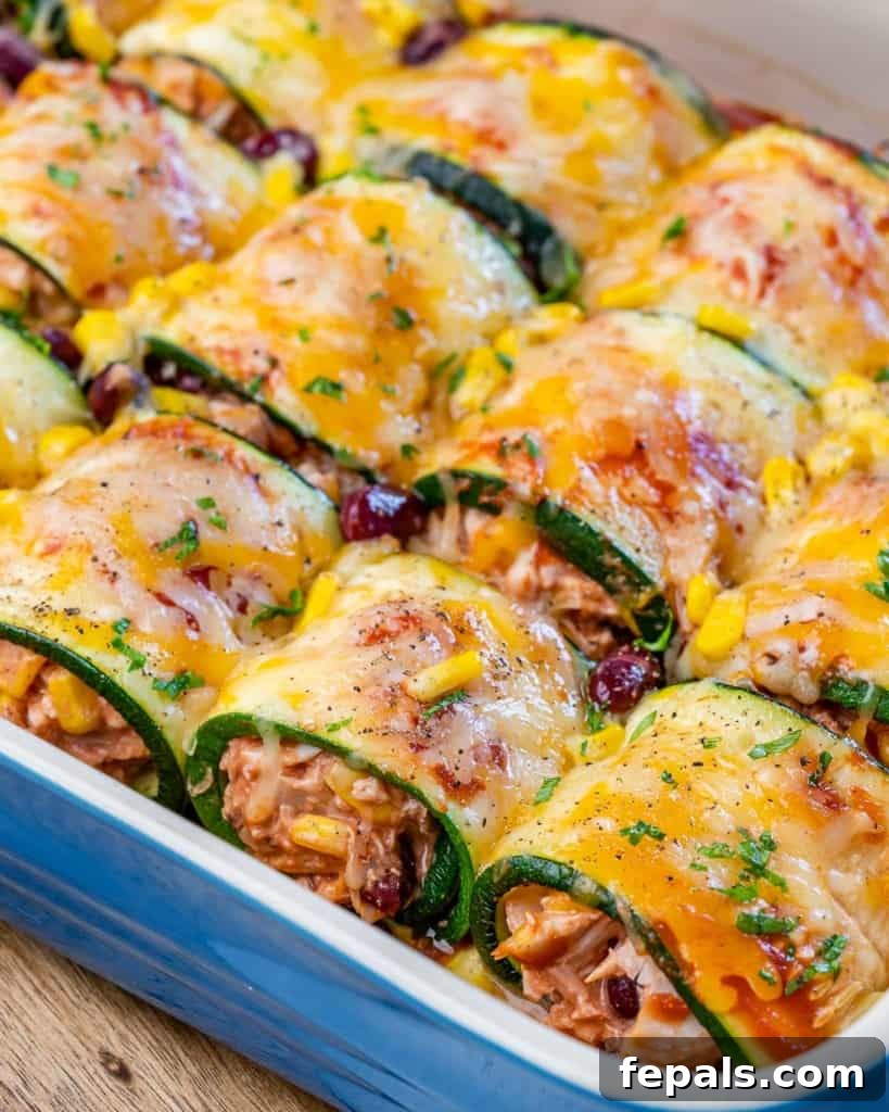 side shot to stuffed chicken enchiladas in a dish with melted cheese and parsley garnish