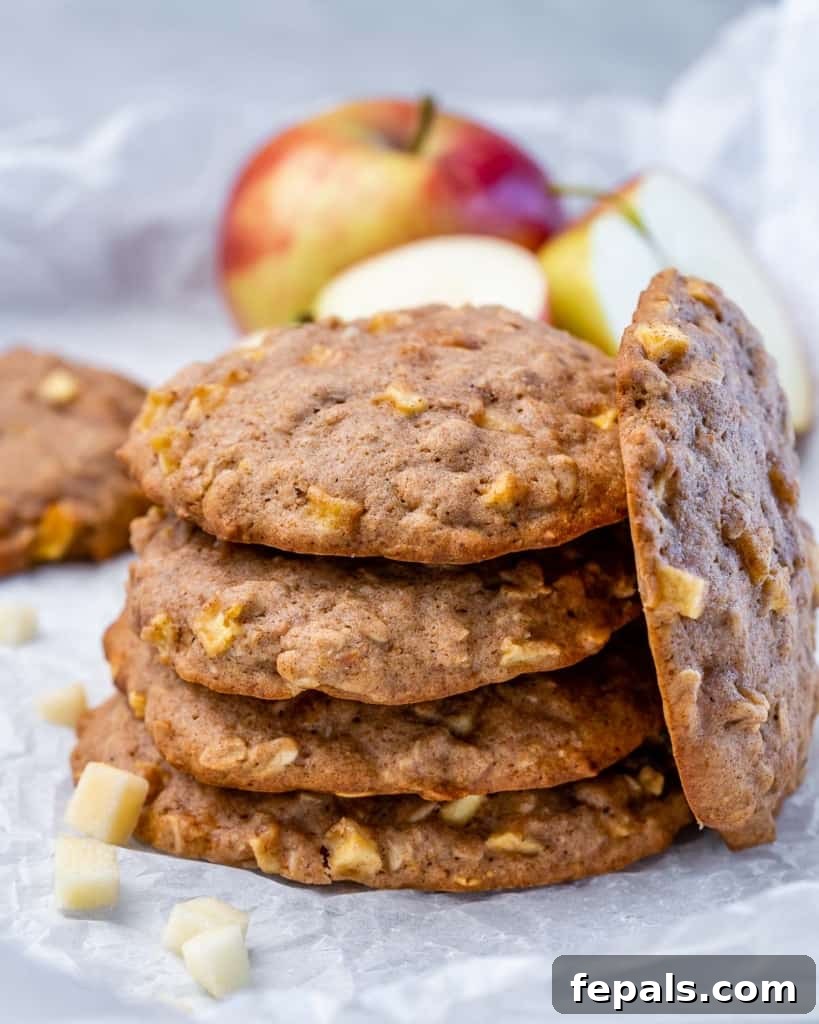 Warm Apple Cinnamon Oat Cookies 11 Stack of apple cookies near a fresh apple.