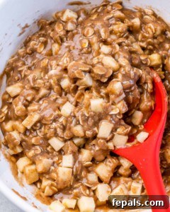 Stirring apple chunks into cookie batter.