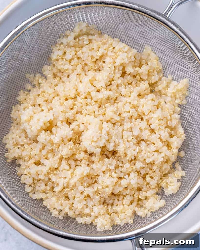 Mediterranean Chickpea Cucumber Quinoa Salad 5 Fluffy cooked quinoa resting in a pot, ready to be cooled and added to the salad.