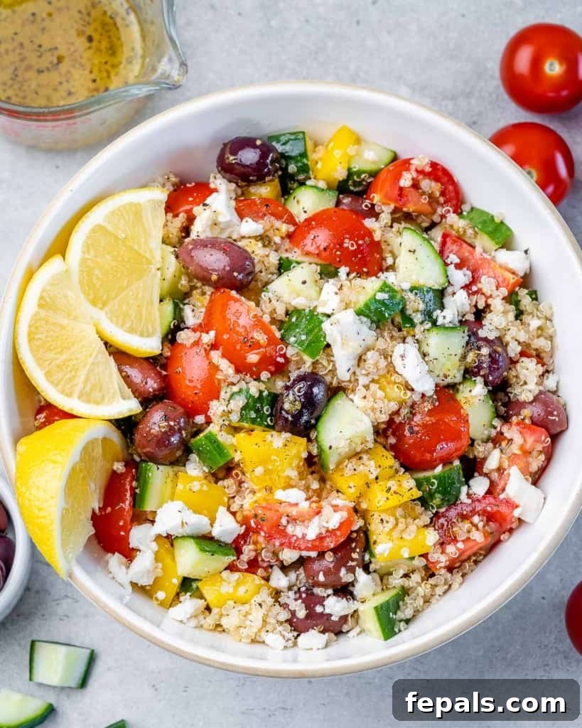 top view quinoa salad bowl topped with lemon slices to garnish and crumbled feta cheese