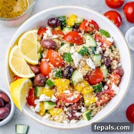 top view of a white bowl with quinoa greek based salad