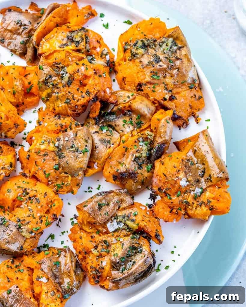 Golden Roasted Sweet Potato Smash 11 A simple white plate holding a serving of perfectly baked and smashed sweet potatoes, ready to be enjoyed as a savory side dish.