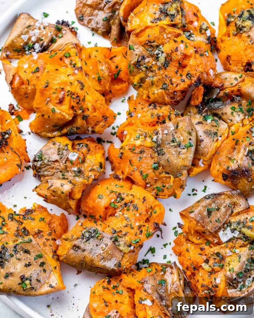 Golden Roasted Sweet Potato Smash 8 A baking sheet filled with perfectly smashed sweet potatoes, glistening with seasoning, ready to be broiled until crispy.