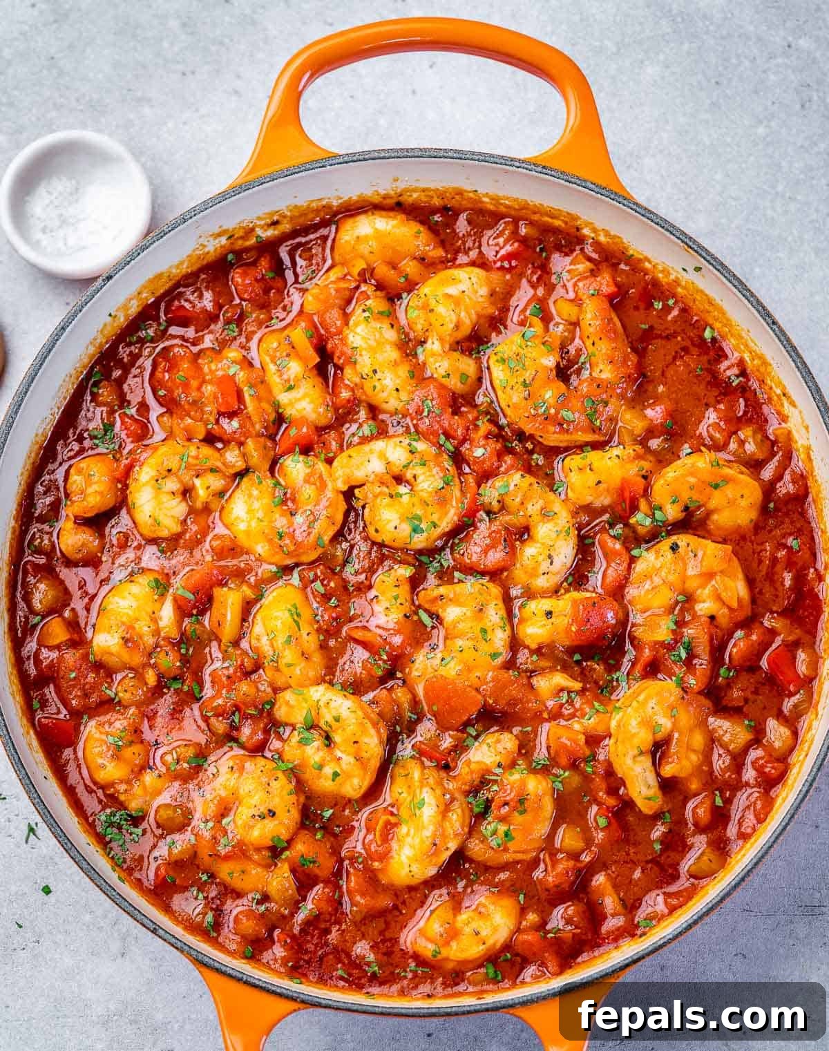 Cooking shrimp creole in a large pot.