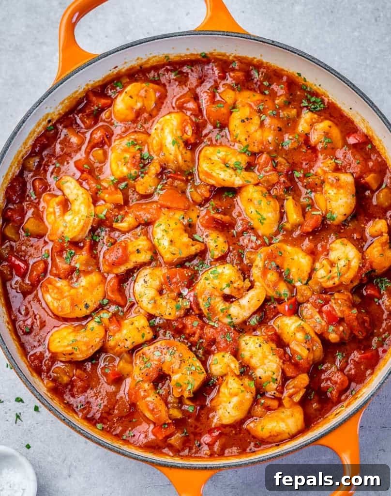 top view of orange skillet with shrimp in a red looking creole sauce 