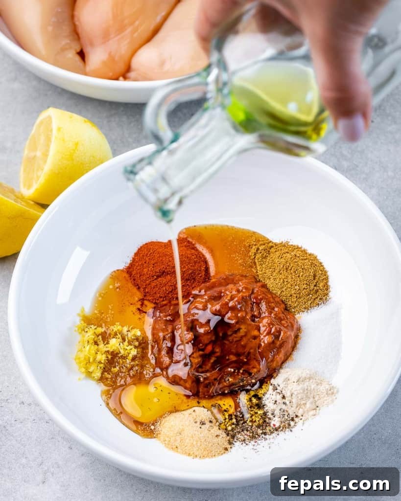 Spicy Harissa Roasted Chicken 5 oil being added over seasonings on a round white plate