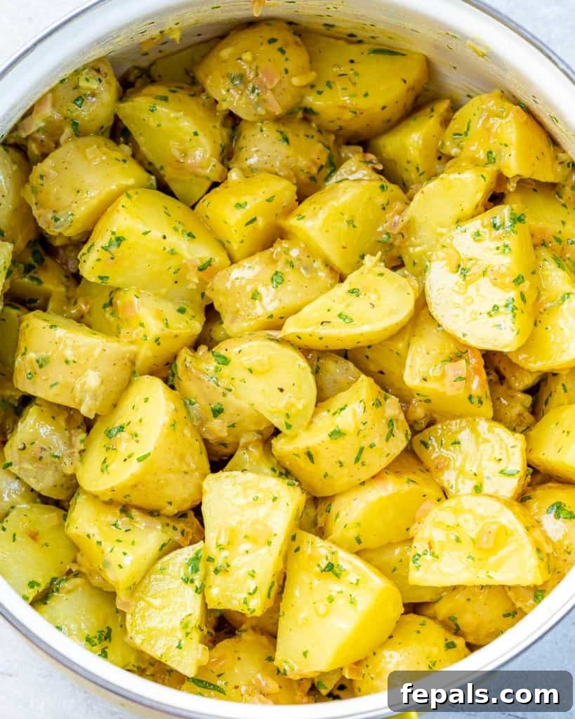 Hearty Warm German Potato Salad 7 Baby combined with dressing and fresh parsley.