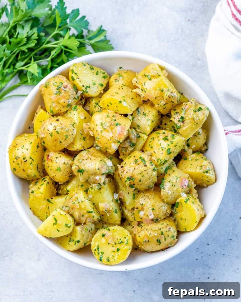 Hearty Warm German Potato Salad 8 top view potato salad chunks on a round white bowl