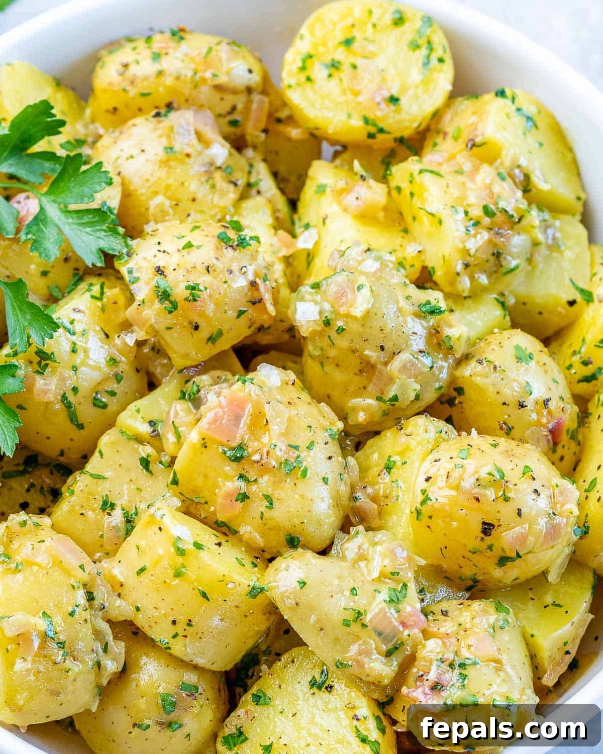 Hearty Warm German Potato Salad 10 German potato salad in a large white bowl.