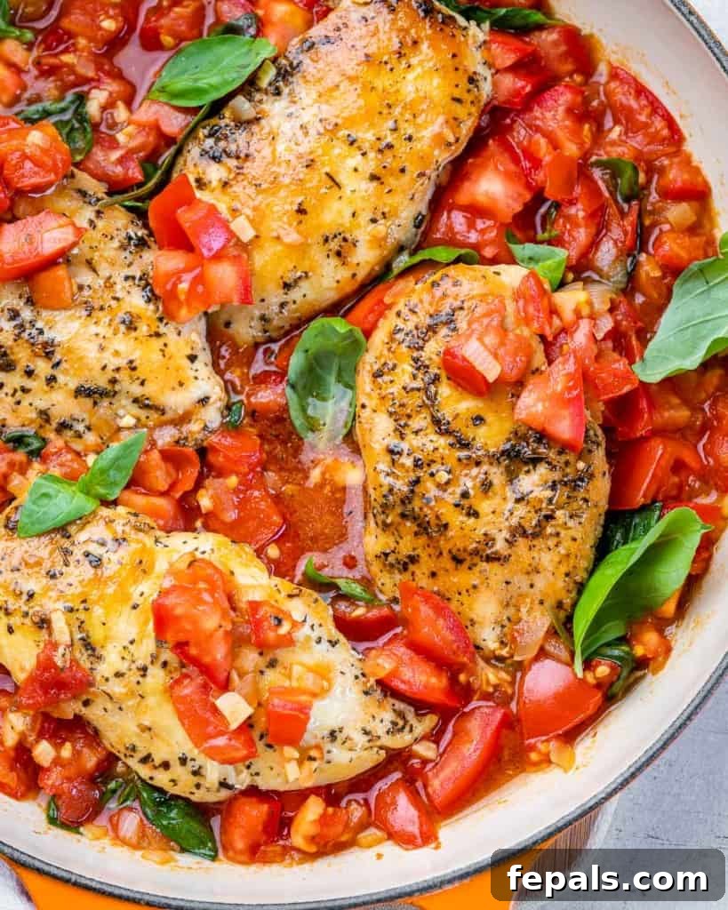 Tuscan Chicken Pomodoro 8 top view of cooked chicken breast in a fresh tomato sauce and topped with basil garnish