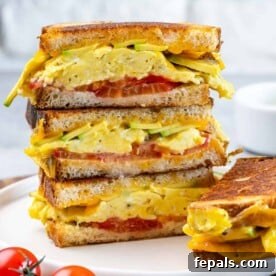 Close-up of a breakfast egg sandwich, showing the golden-brown bread and fillings.