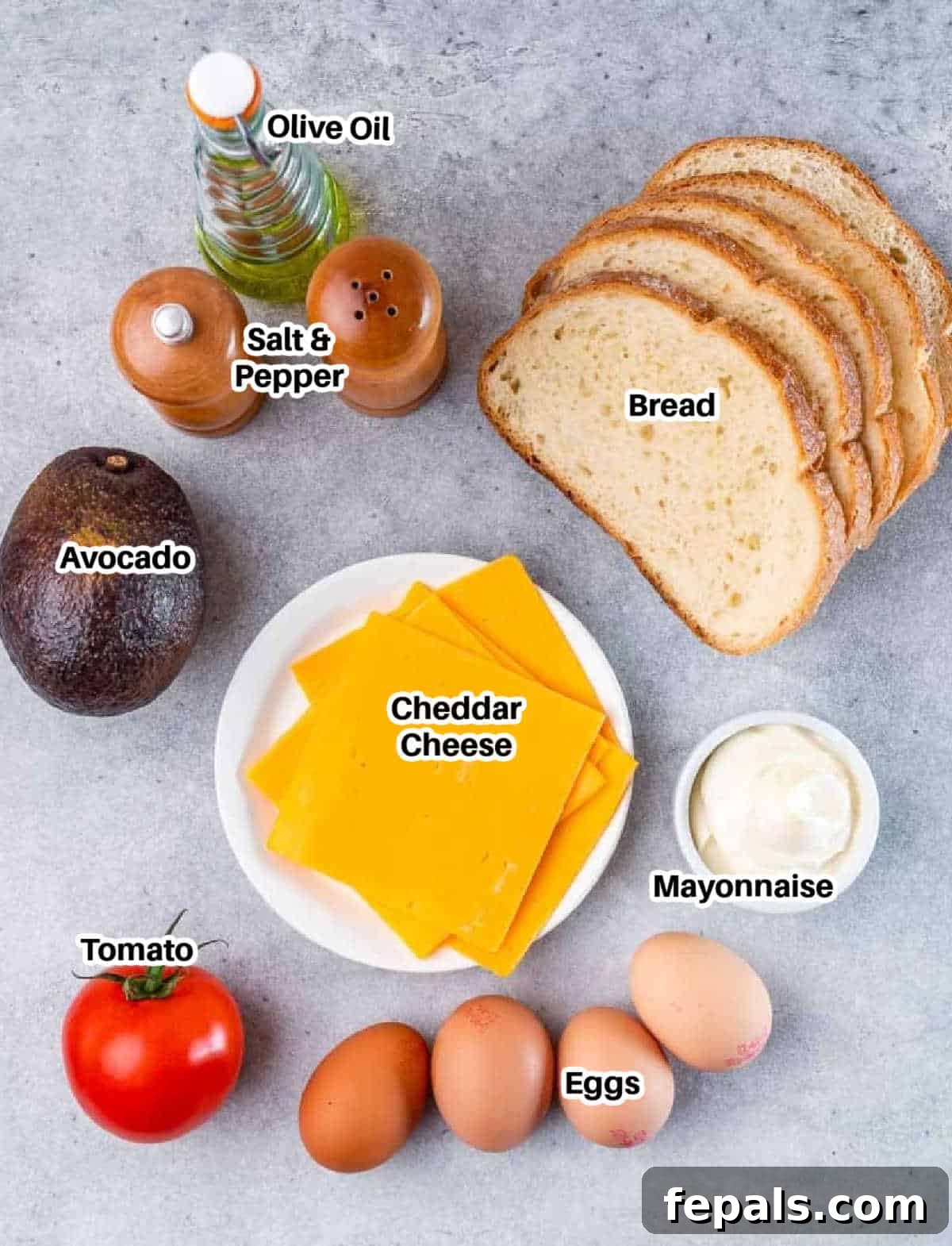 An array of fresh ingredients neatly arranged for making breakfast egg sandwiches, featuring eggs, bread, cheese, avocado, and tomato.