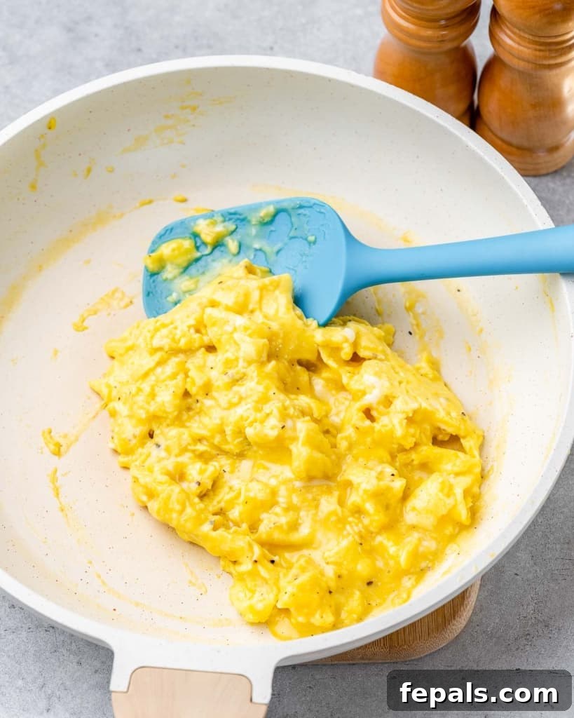 Scrambling eggs in a skillet, demonstrating the light and fluffy texture as they cook.