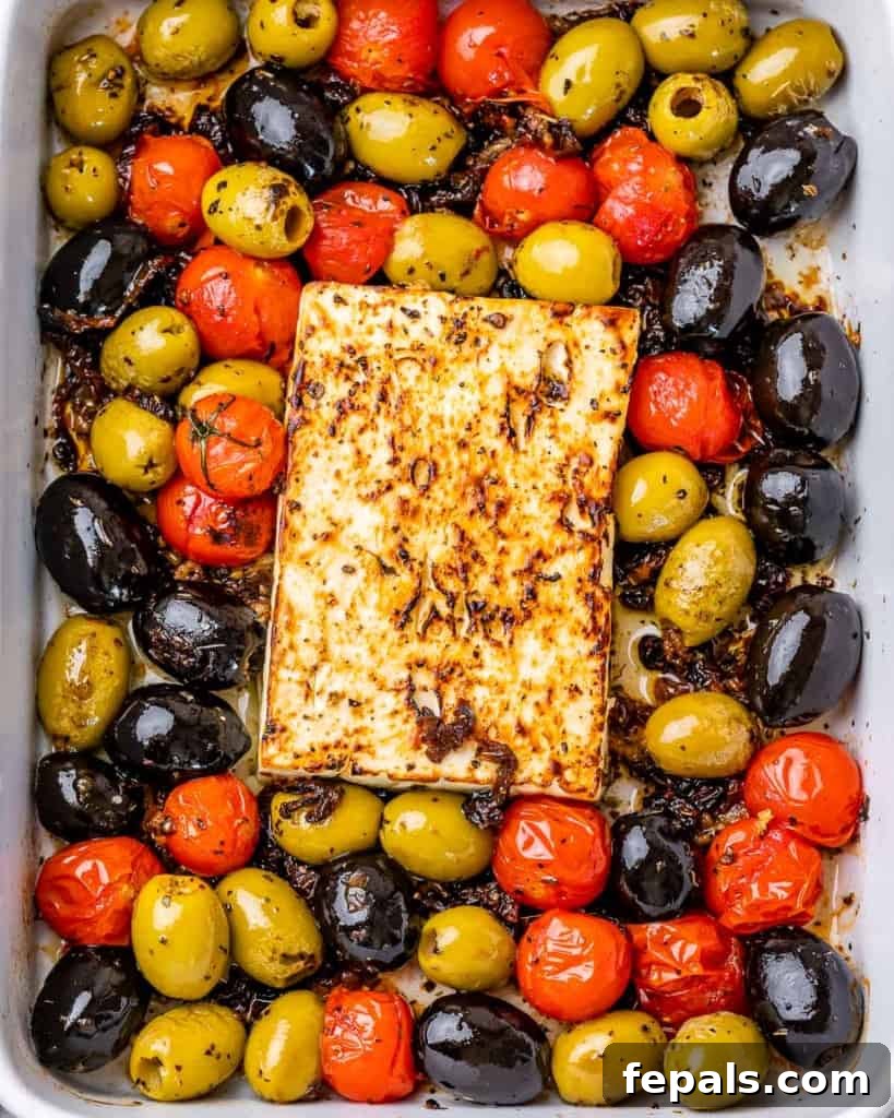 top view close up of baked feta cheese with olives and tomatoes, ready to be served