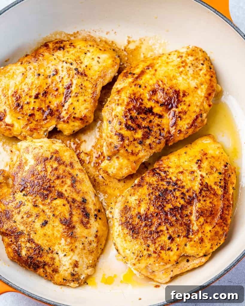 Searing chicken breast in a skillet.