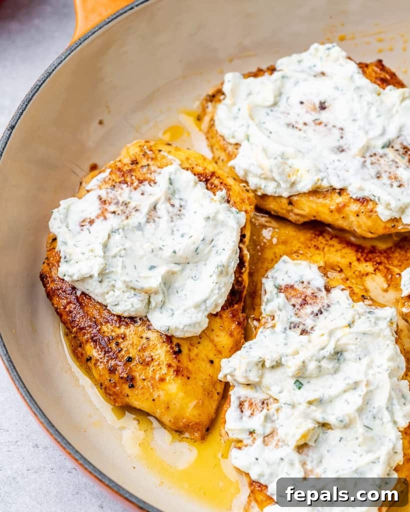 Covering chicken with cream cheese mixture.