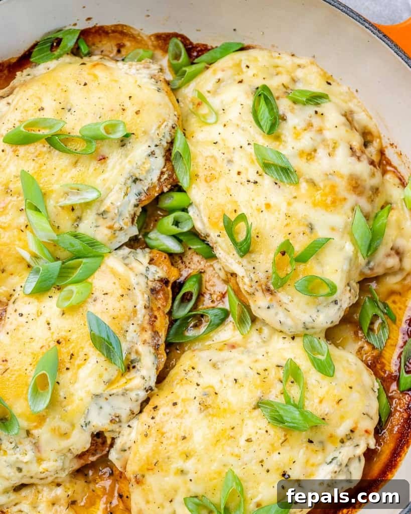 top view close up of chicken breast on skillet topped with melted cheese