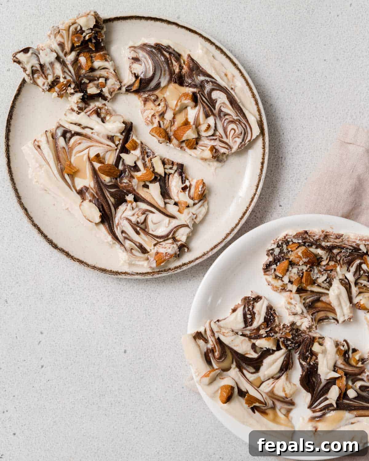 Peanut Butter Yogurt Frosty Bark 14 Close-up of frozen yogurt bark swirled with peanut butter and chocolate, presented elegantly on a plate.