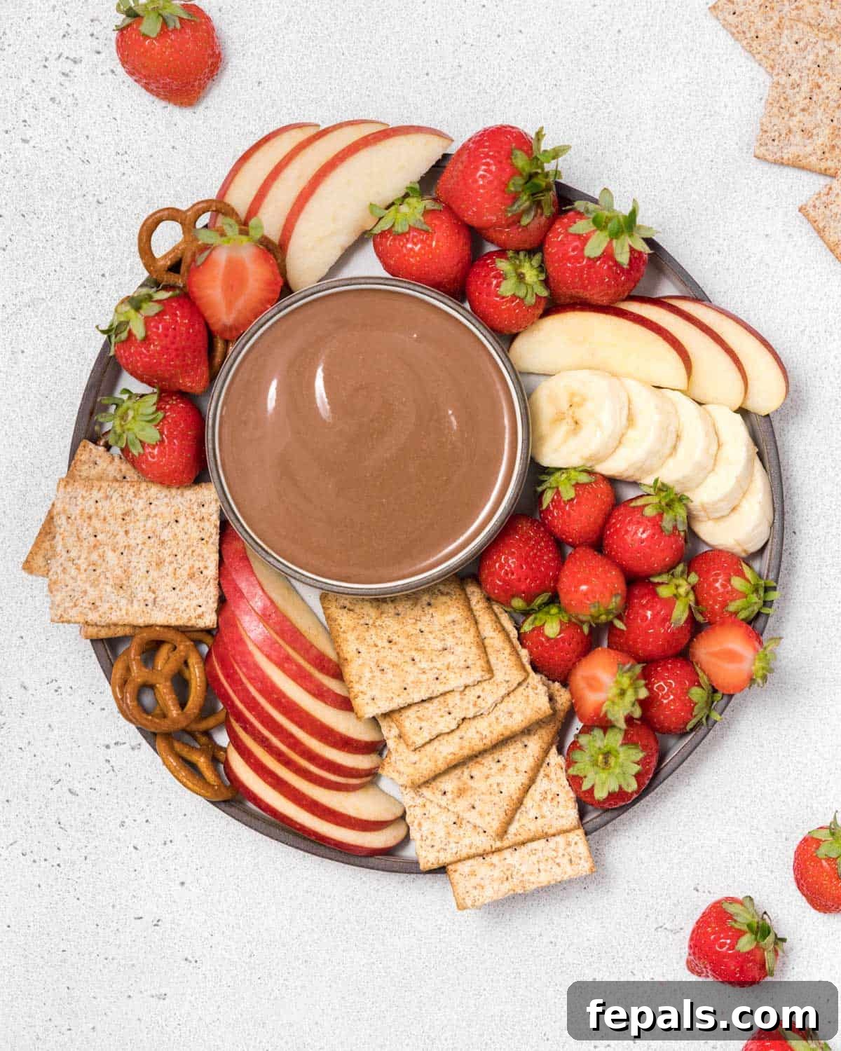 Top view yogurt dip in a bowl with crackers and fruits, showcasing its creamy texture and inviting presentation.