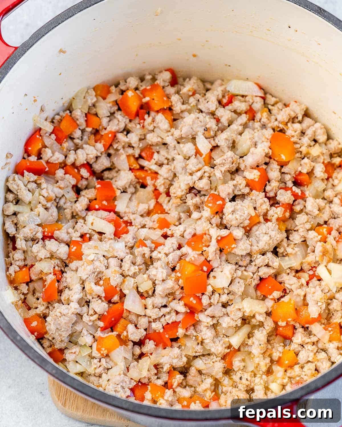 Sautéed diced onion, bell pepper, and minced garlic with browning ground turkey in a large Dutch oven pot.