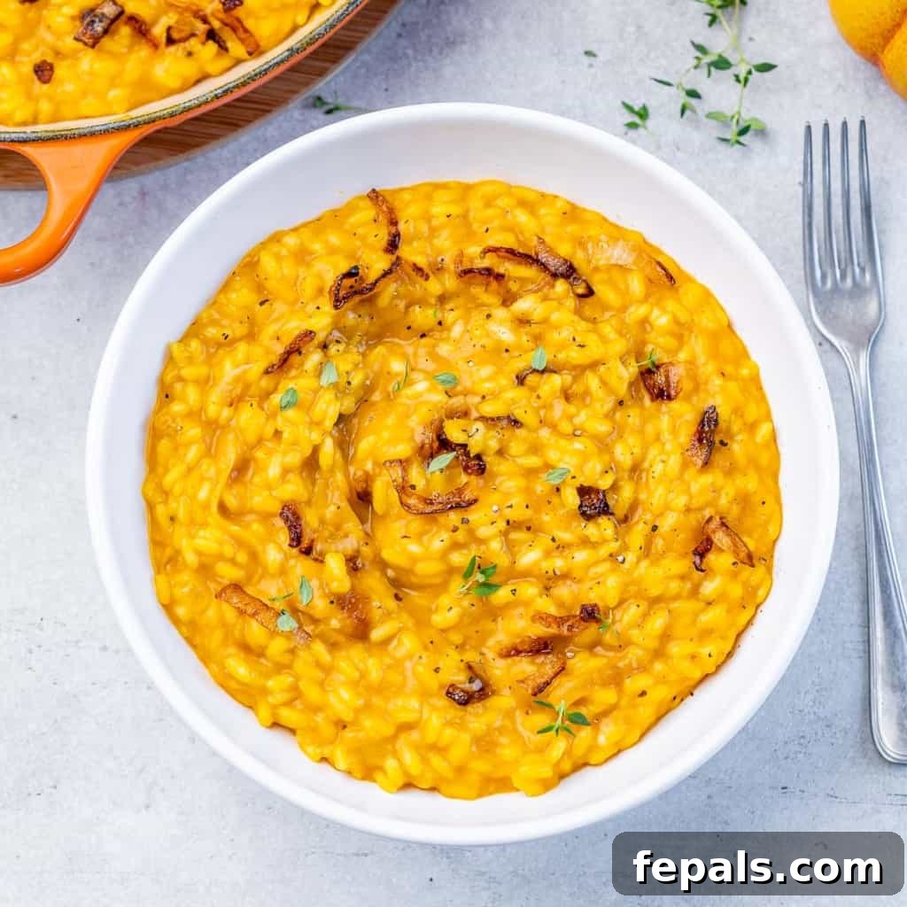 Velvet Pumpkin Risotto Easy Autumn Meal 7 Top view of creamy pumpkin risotto in a white round bowl, garnished with fresh herbs.