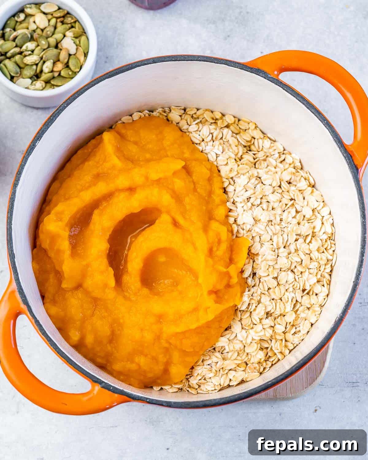 Pumpkin puree and rolled oats combined in a large pot.