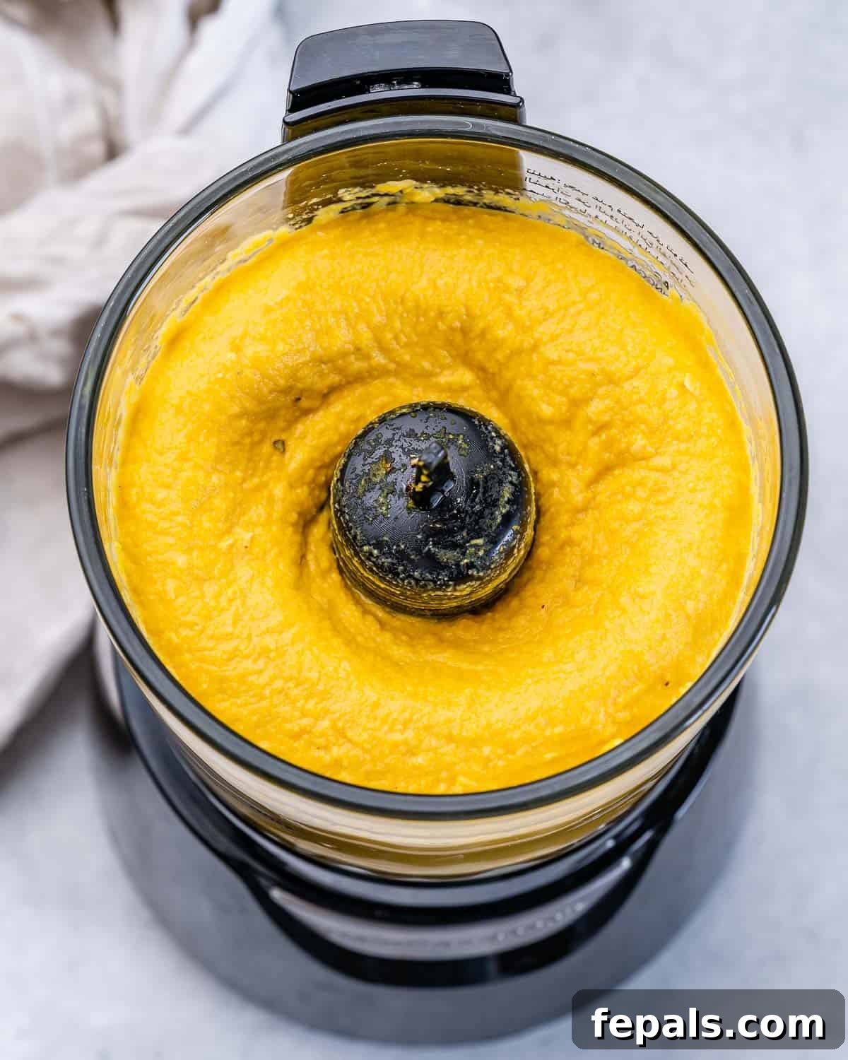 Spiced Pumpkin Hummus 7 Blended pumpkin hummus in a food processor.