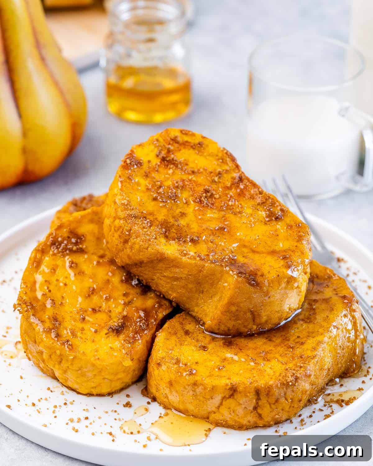 French toast made with pumpkin puree and pumpkin spice on a white plate.