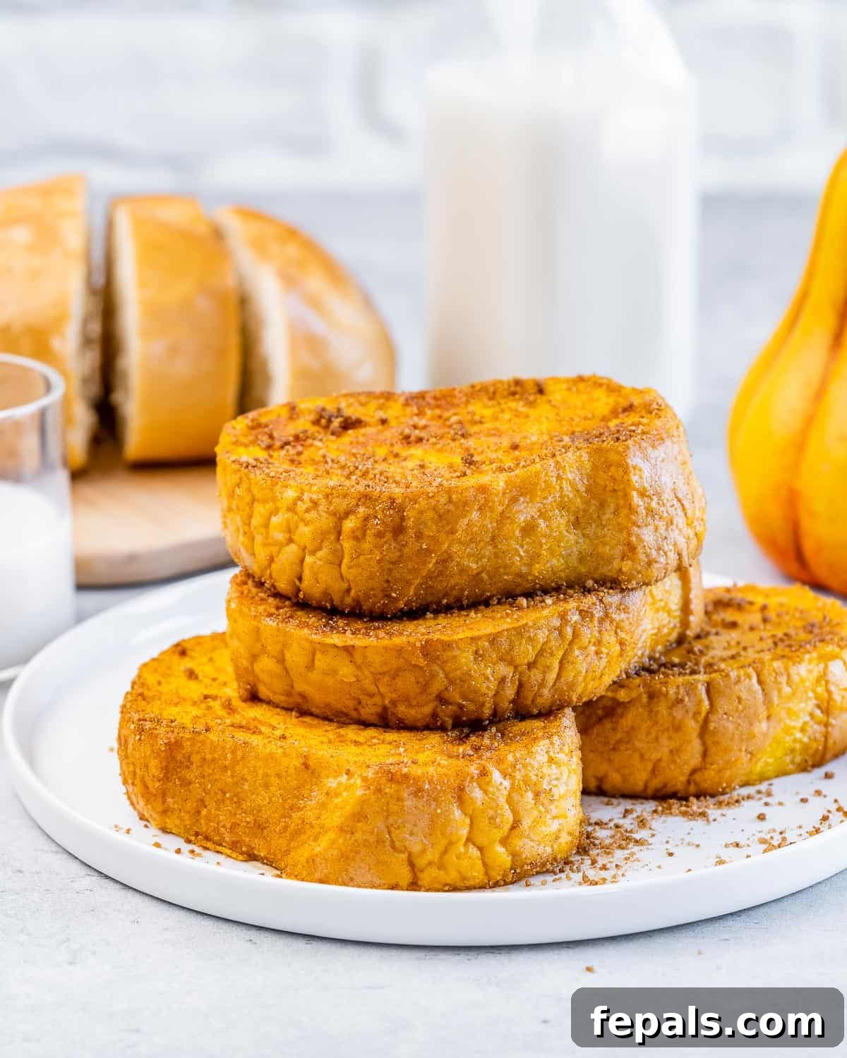 Pieces of pumpkin French toast stacked on a white plate.