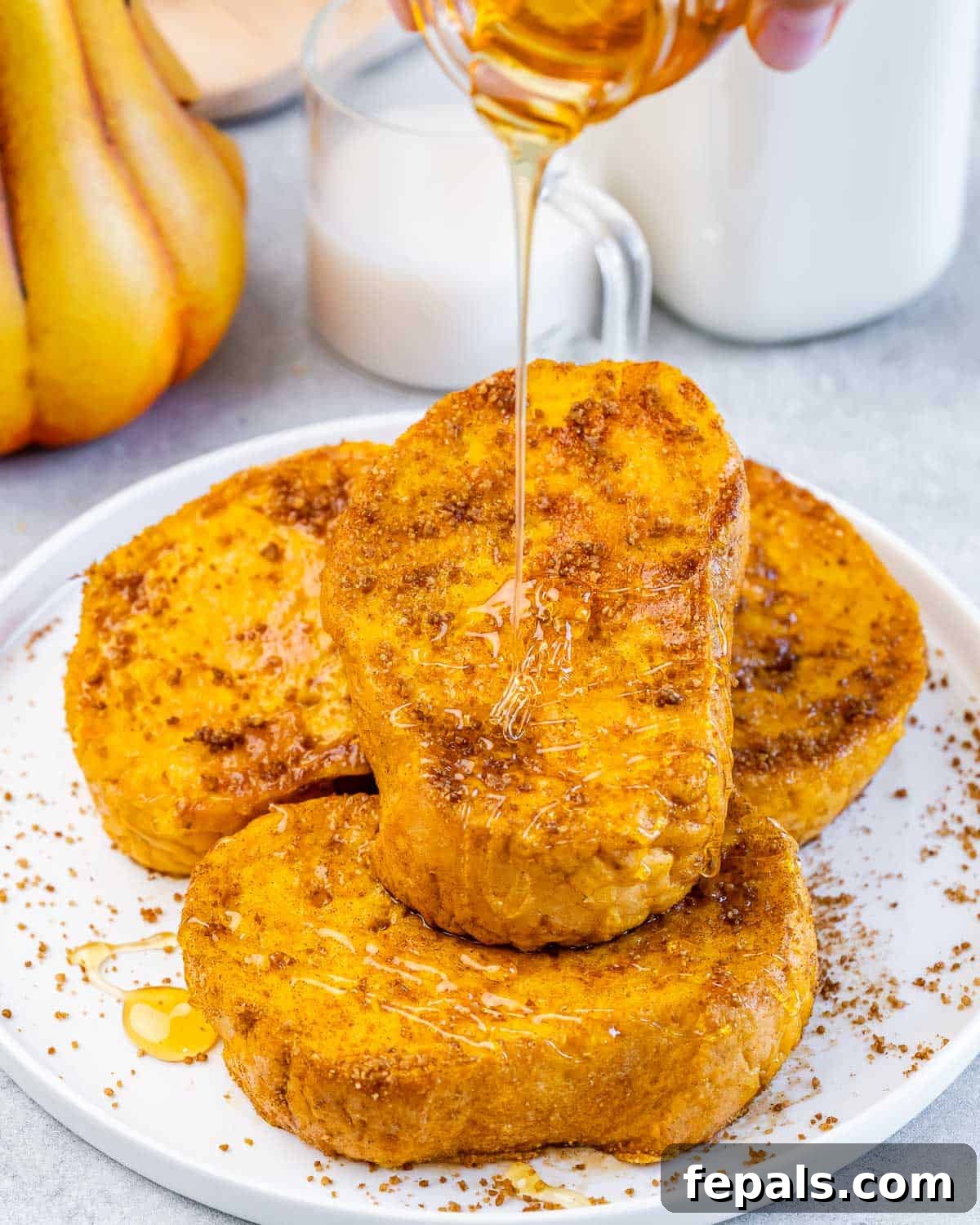 Drizzling maple syrup over a plate of French toast.