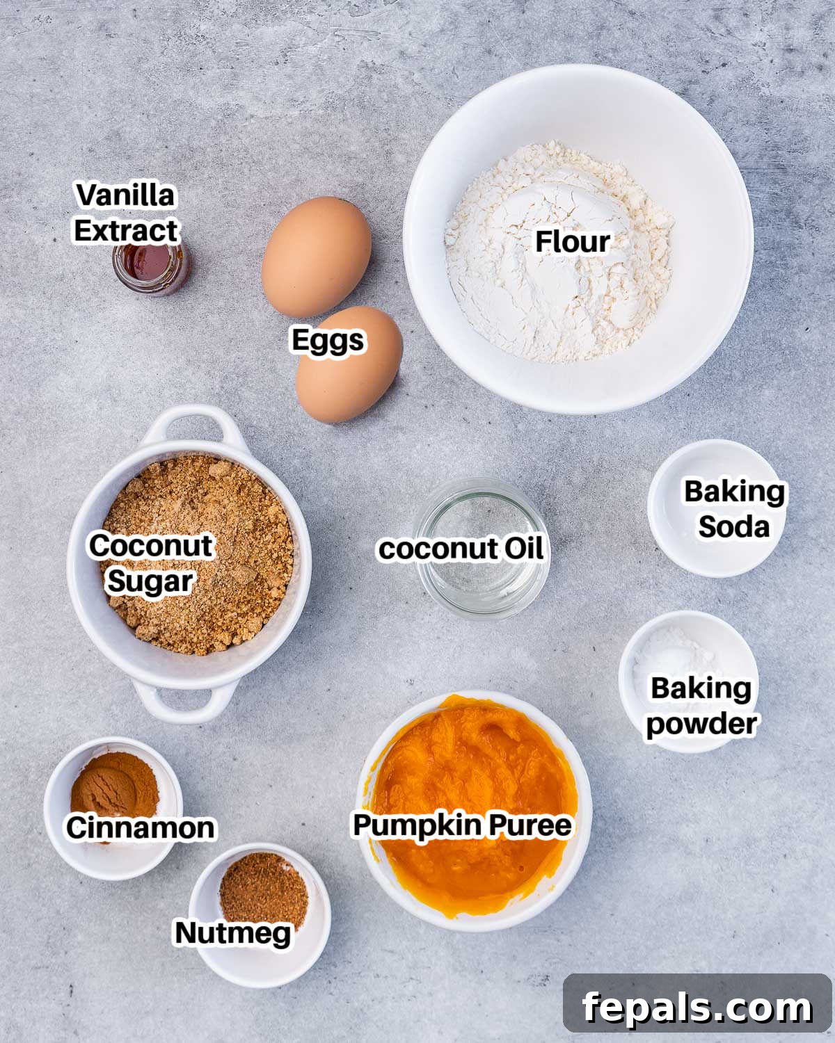 Collection of ingredients to make healthy pumpkin bread, including eggs, pumpkin puree, flour, coconut sugar, and spices.