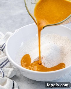 Pouring pumpkin mixture into flour mixture.