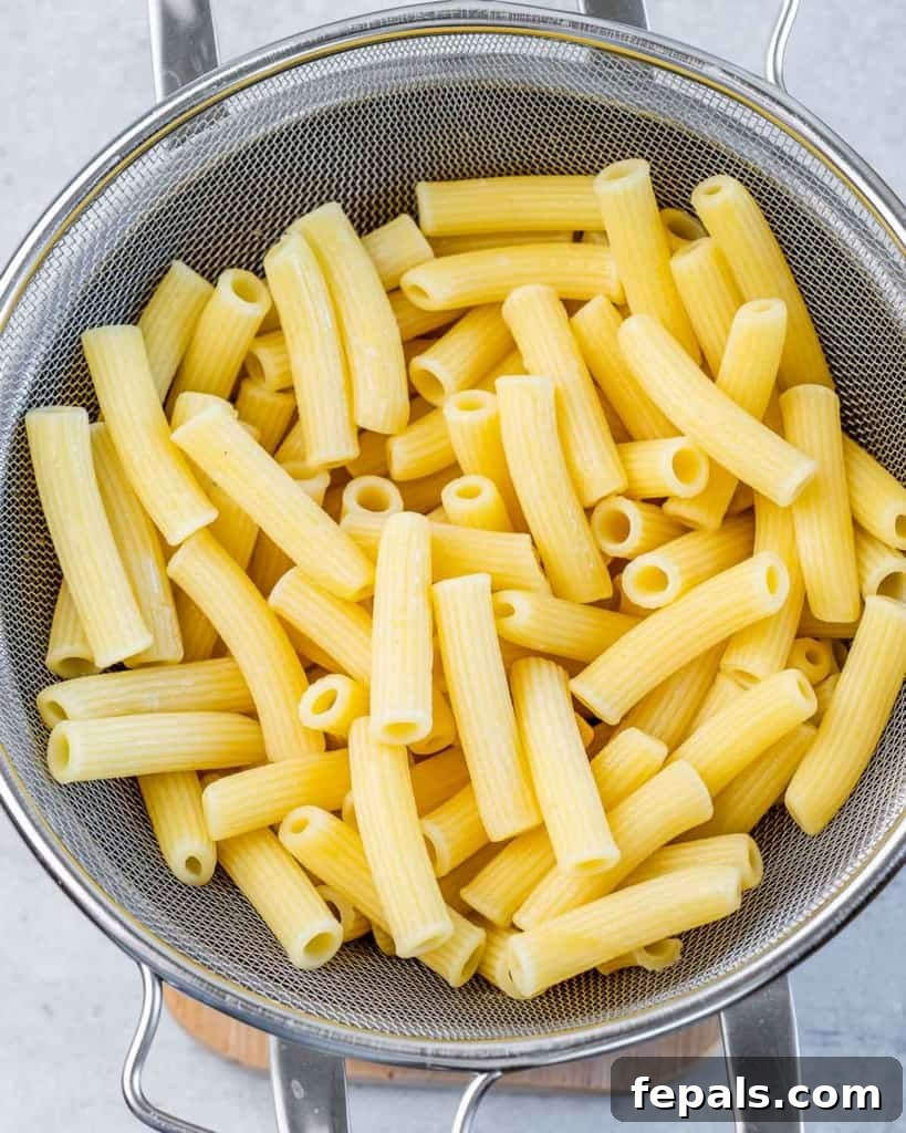 Close-up of pasta being drained in a colander, steam rising.