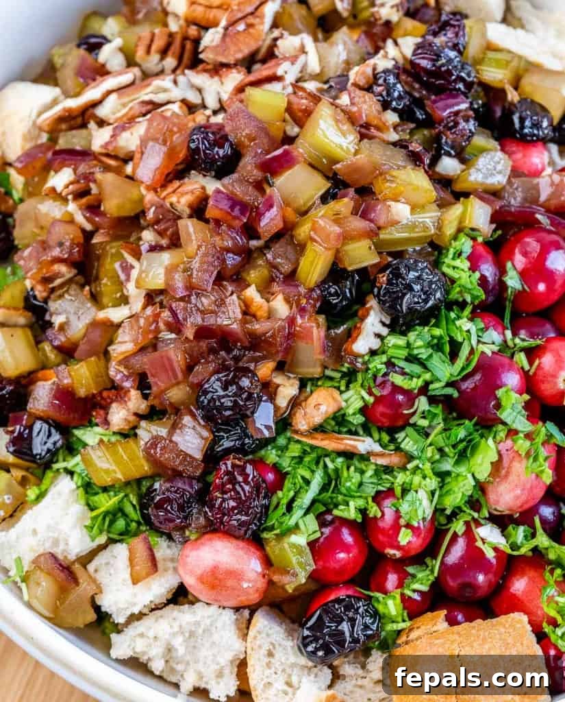 Golden Herb Roasted Sheet Pan Turkey Breast 7 Combining the savory vegetable mixture with toasted bread cubes and fresh ingredients in a bowl.